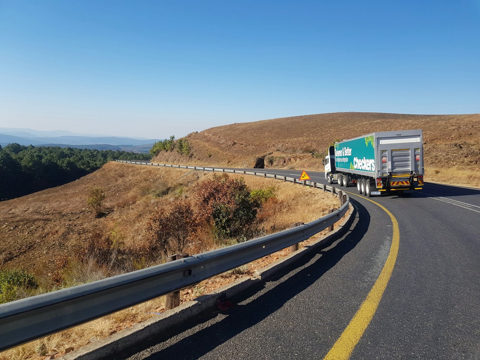 A freight truck on a South African highway through dry hills